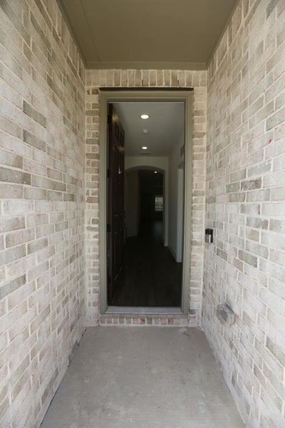 Inviting entryway with light-toned brick facade and a concrete landing