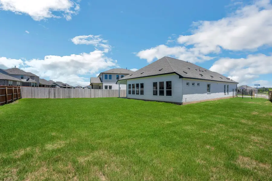 Rear view of house featuring a fenced backyard, a residential view, and brick siding