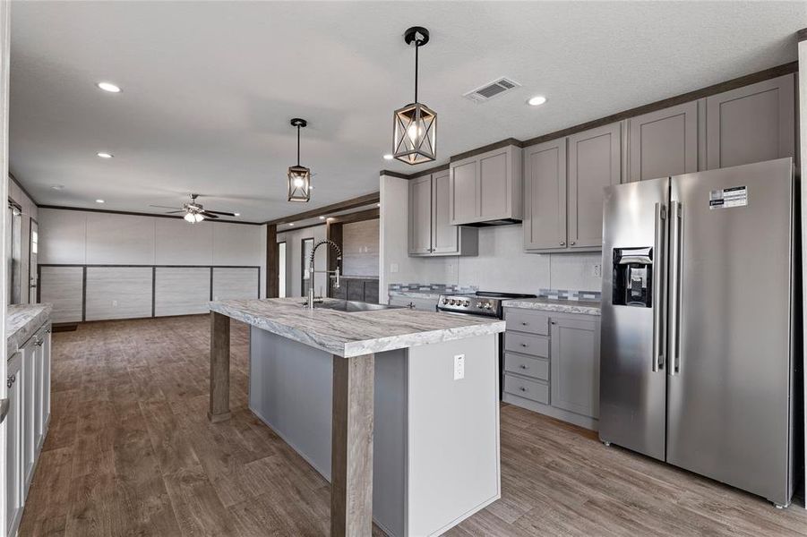 Kitchen with stainless steel appliances, gray cabinets, dark wood finished floors, and a ceiling fan