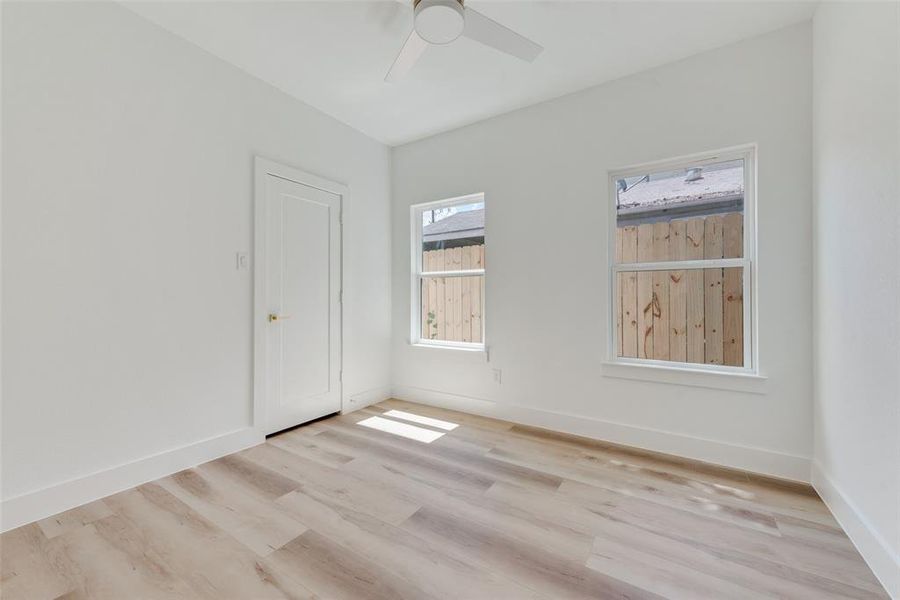 Empty room with light hardwood / wood-style floors and ceiling fan