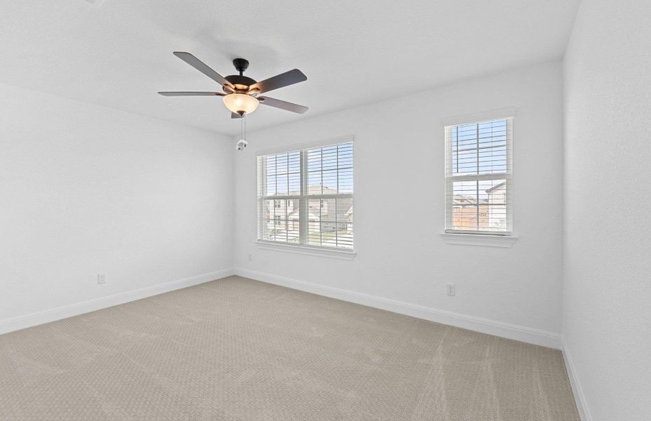 Spare room featuring healthy amount of natural light, light carpet, and ceiling fan Spare room featuring healthy amount of natural light, light carpet, and ceiling fan