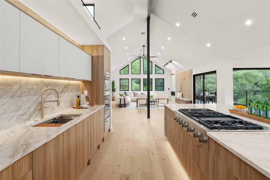 Kitchen with modern cabinets, a sink, stainless steel gas cooktop, healthy amount of natural light, and beamed ceiling
