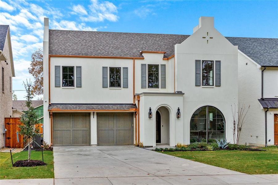 View of front of house featuring roof with shingles, stucco siding, and driveway