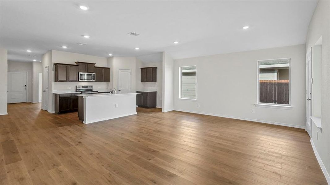 Kitchen featuring open floor plan, an island with sink, stainless steel appliances, healthy amount of natural light, and recessed lighting