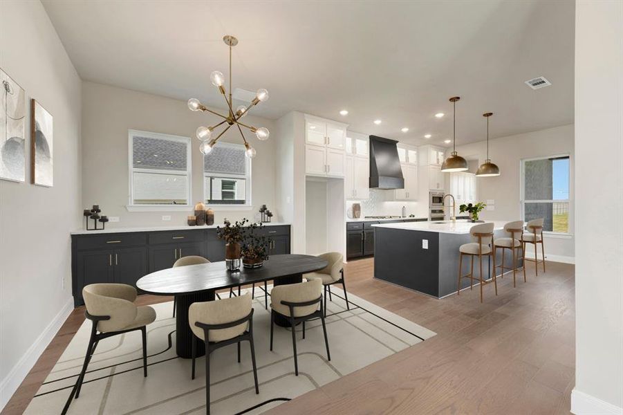 Dining room with light wood-type flooring and suspended lighting Dining room with light wood-type flooring and suspended lighting