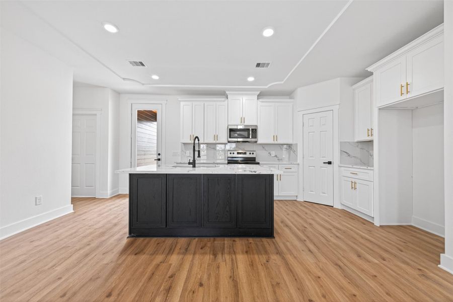 Modern kitchen with abundant cabinetry, large center island, and generous counter space.