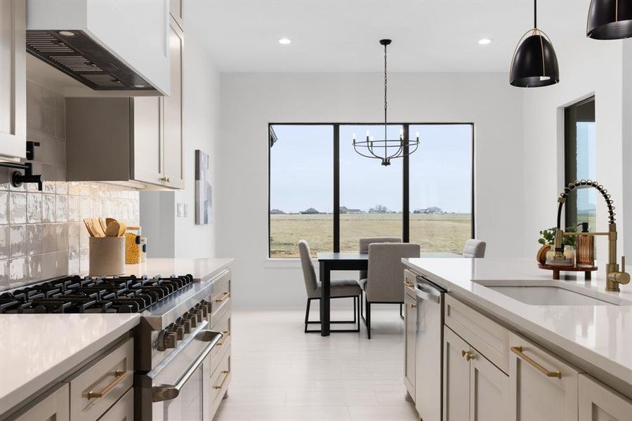 Kitchen featuring hanging light fixtures, stainless steel appliances, sink, and wall chimney exhaust hood