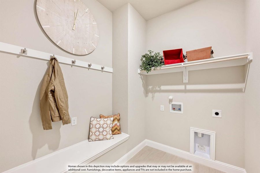 Mudroom with wall coat hooks, built-in bench, upper storage shelf, and light wood floors