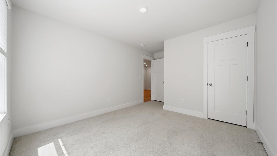 Highly functional bedroom with walk-in closet and tasteful carpet for a restful retreat Highly functional bedroom with walk-in closet and tasteful carpet for a restful retreat