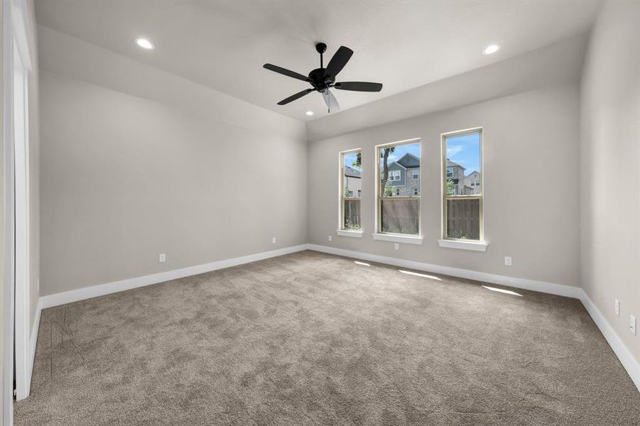 Carpeted empty room featuring ceiling fan