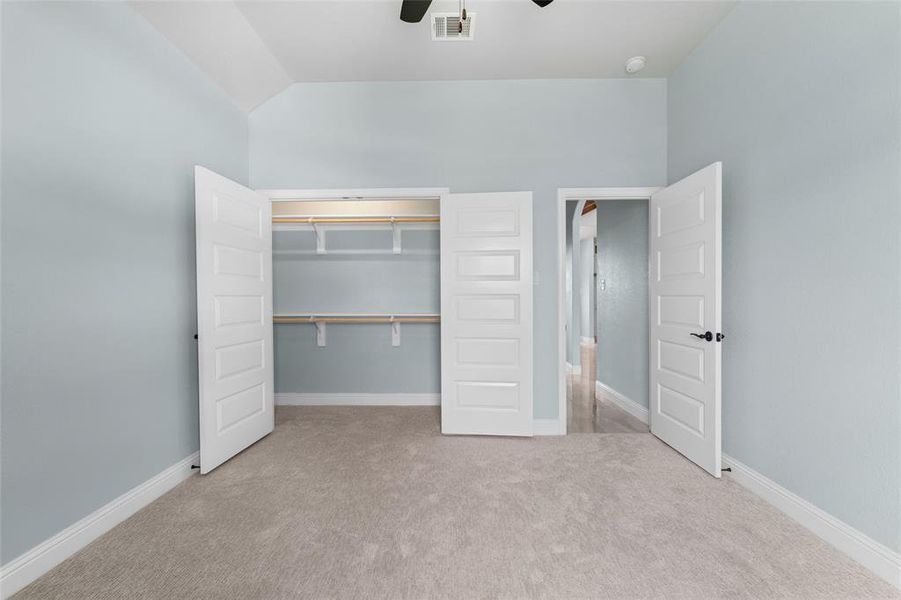 Unfurnished bedroom featuring carpet flooring, a closet, and ceiling fan