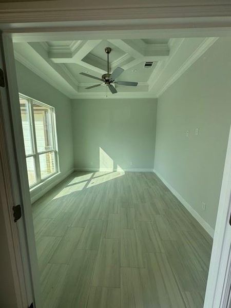 Unfurnished room with crown molding, coffered ceiling, wood finish floors, beam ceiling, and a ceiling fan