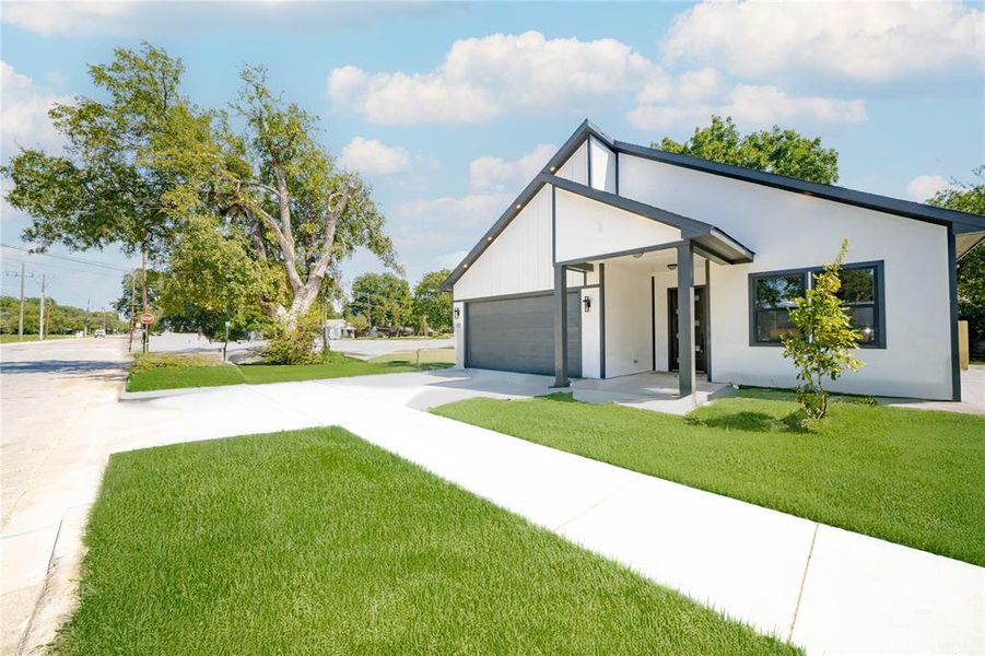 View of front of property with driveway, a front yard, a garage, and stucco siding View of front of property with driveway, a front yard, a garage, and stucco siding