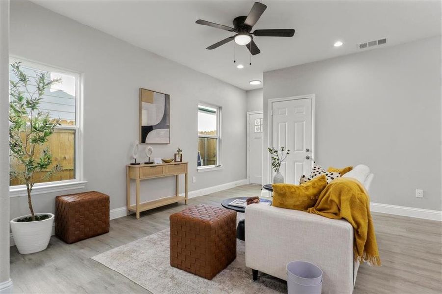 Living room with light wood-type flooring and ceiling fan