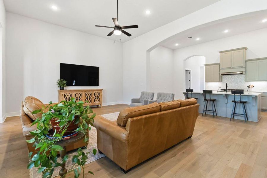 An open-concept living area with soaring ceilings seamlessly transitions to a modern kitchen.