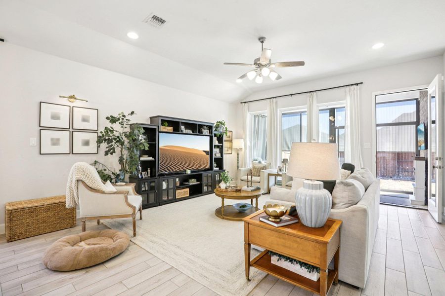 Living room with wood tiled floors, ceiling fan, recessed lighting, and lofted ceiling