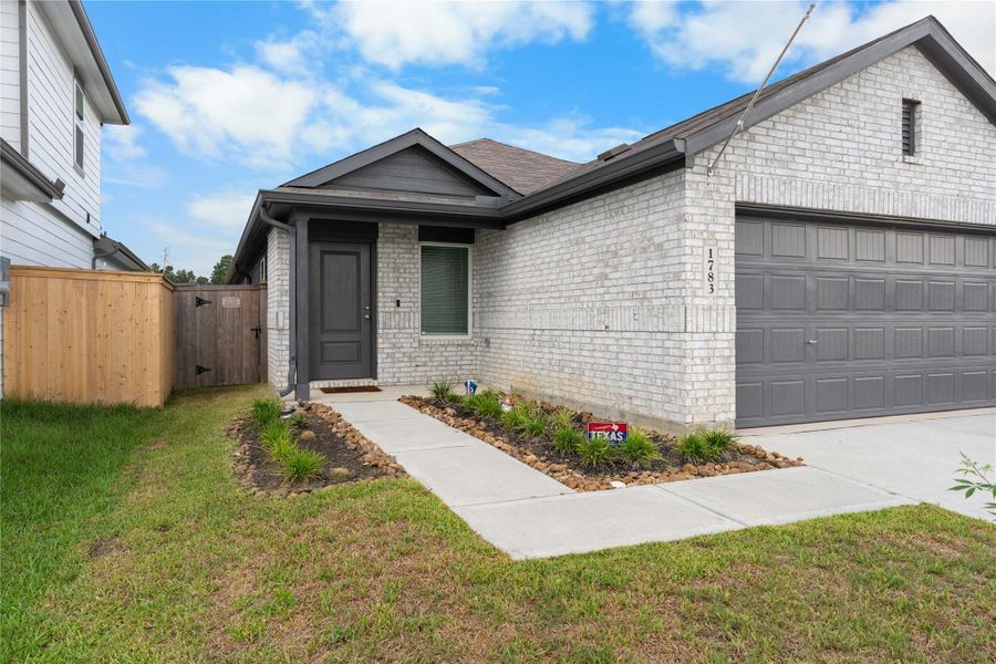 Welcoming walkway leads through the landscaped entry to the front door, complemented by the home’s classic brick exterior.
