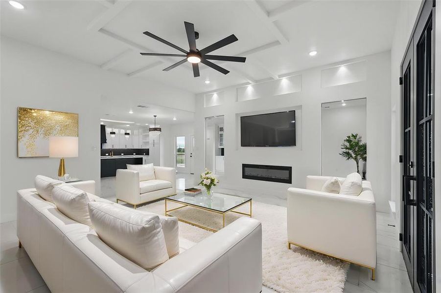 Living area with ceiling fan, recessed lighting, a glass covered fireplace, and beam ceiling Living area with ceiling fan, recessed lighting, a glass covered fireplace, and beam ceiling