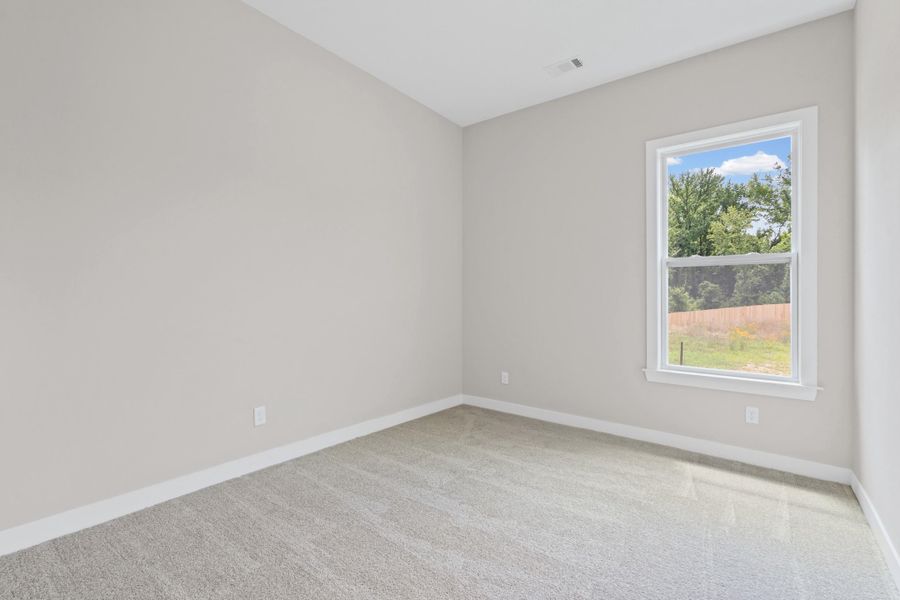 Light gray wall paint with white trim, gray carpet flooring, and a single window with white framing Light gray wall paint with white trim, gray carpet flooring, and a single window with white framing