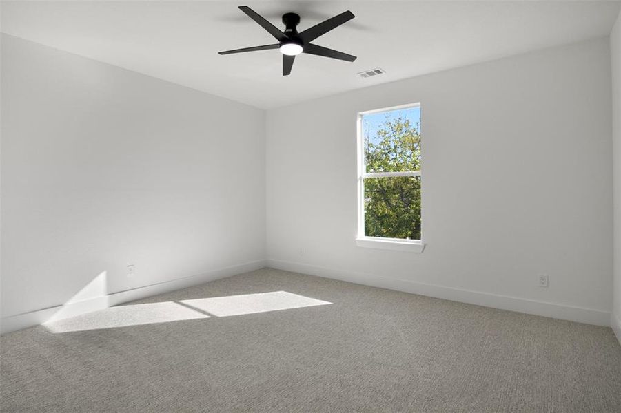 Carpeted spare room with ceiling fan