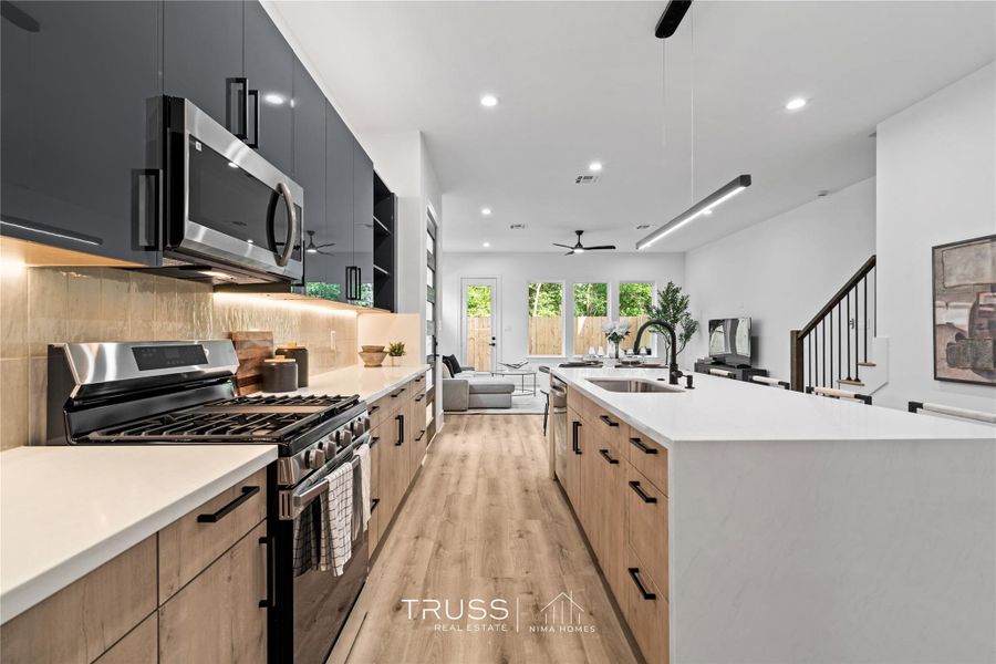 A seamless blend of form and function, this open layout connects kitchen, dining, and living spaces with effortless flow. Clean lines, matte black accents, and Nima Homes’ signature craftsmanship create an atmosphere of understated sophistication.