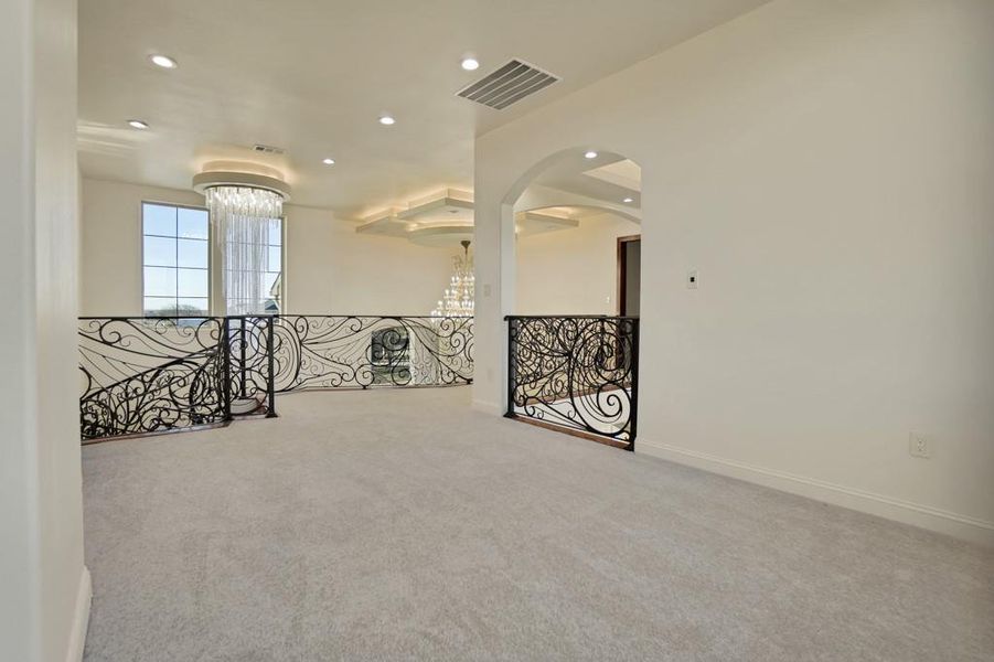 Empty room featuring carpet flooring and a notable chandelier