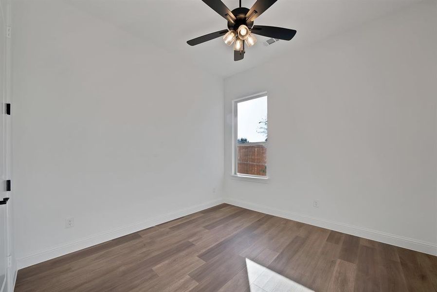 Secondary bedroom with dark wood-style flooring and ceiling fan