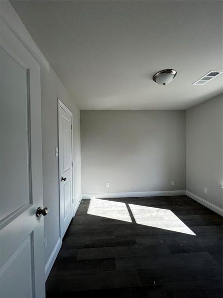 Empty room featuring dark hardwood / wood-style floors