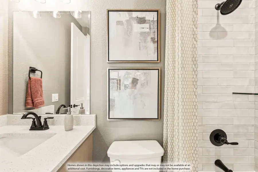 Bathroom with quartz countertop, black fixtures, large mirror, and tiled shower with curtain