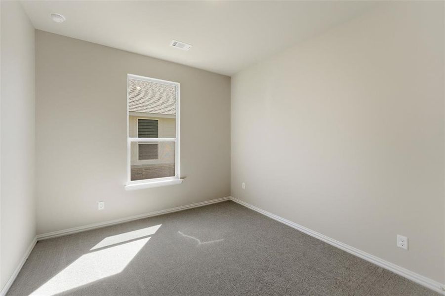 Spare room featuring carpet flooring and baseboards
