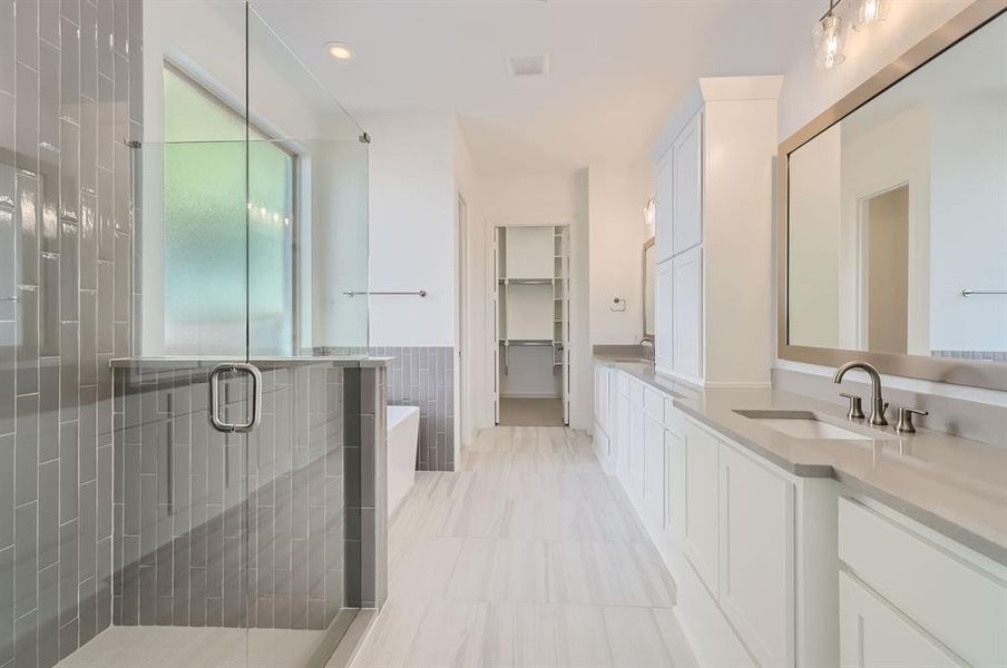 Bathroom with vanity, shower with separate bathtub, and tile walls