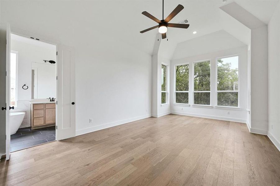 Unfurnished bedroom featuring light wood-style flooring, a ceiling fan, connected bathroom, lofted ceiling, and recessed lighting Unfurnished bedroom featuring light wood-style flooring, a ceiling fan, connected bathroom, lofted ceiling, and recessed lighting