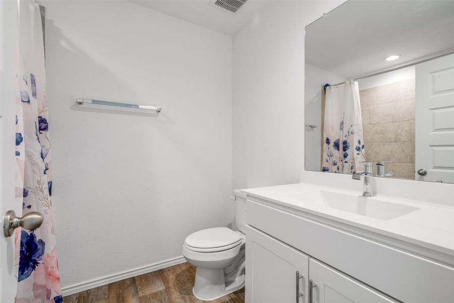 This bathroom features a tiled shower/tub combo, sleek tile flooring, and a contemporary vanity with a quartz countertop. This bathroom features a tiled shower/tub combo, sleek tile flooring, and a contemporary vanity with a quartz countertop.