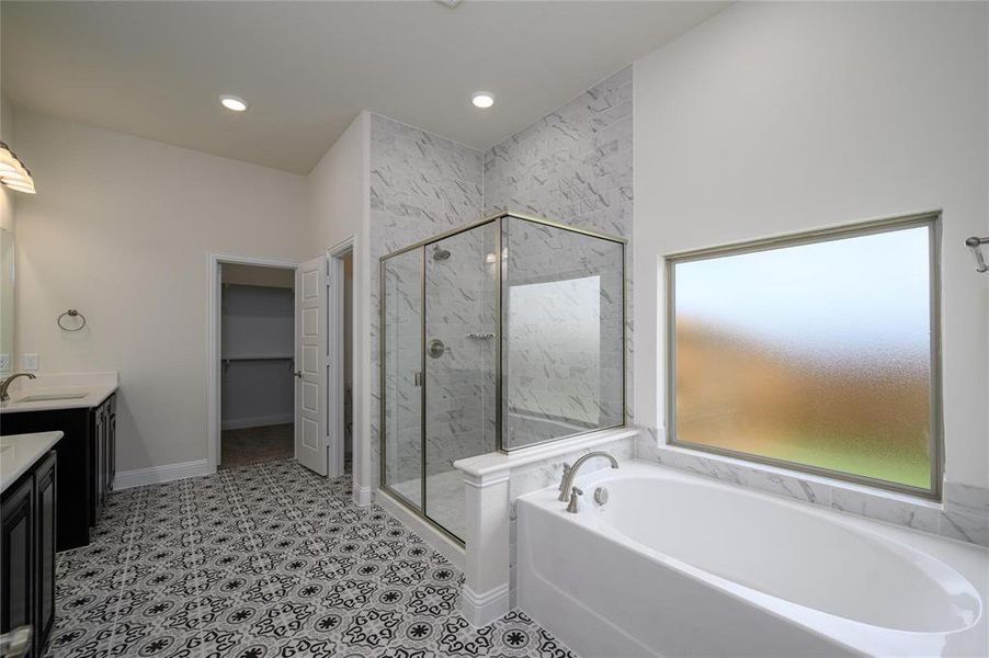 Bathroom with tile patterned floors, vanity, and separate shower and tub