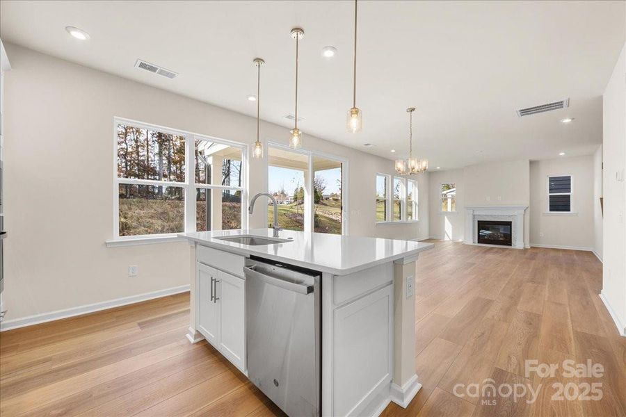 Large Central Island Featuring Quartz Countertops and Designer Pendant Lighting.