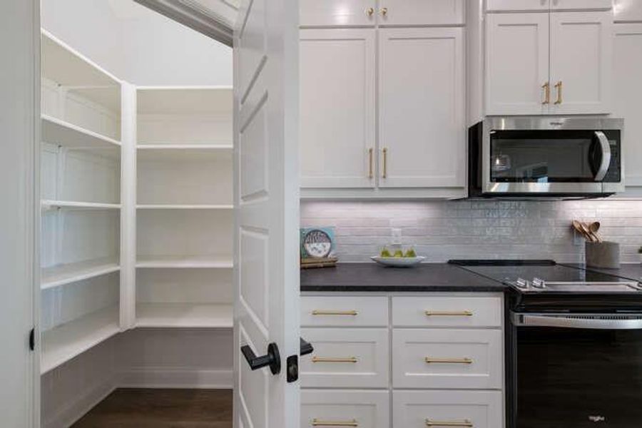 Kitchen area featuring white cabinets and pantry Kitchen area featuring white cabinets and pantry