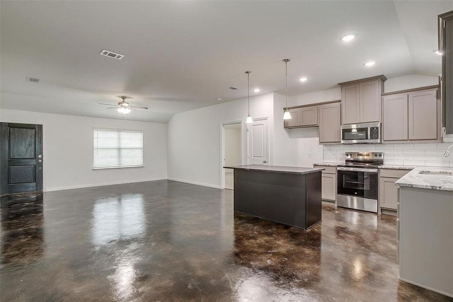 Kitchen with decorative backsplash, stainless steel appliances, hanging light fixtures, gray cabinets, and recessed lighting