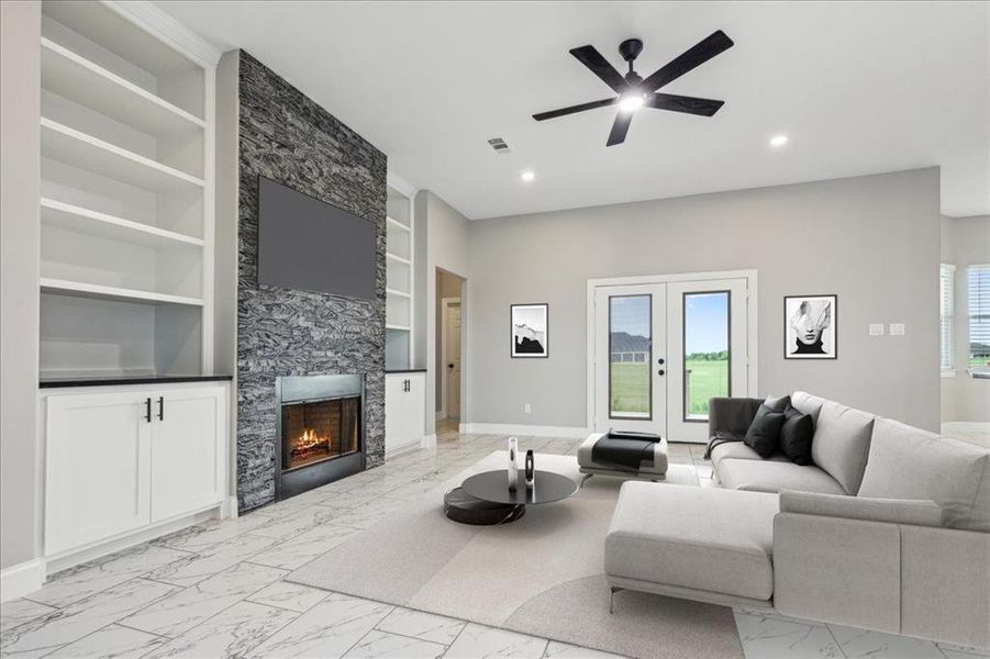 Tiled living room featuring built in features, ceiling fan, french doors, and a tile fireplace