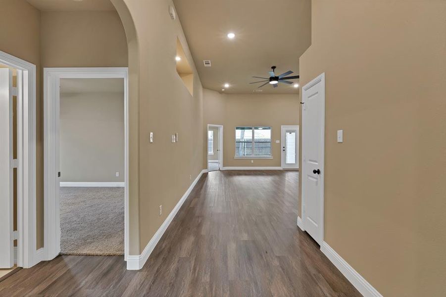 Corridor featuring dark wood finished floors and baseboards Corridor featuring dark wood finished floors and baseboards