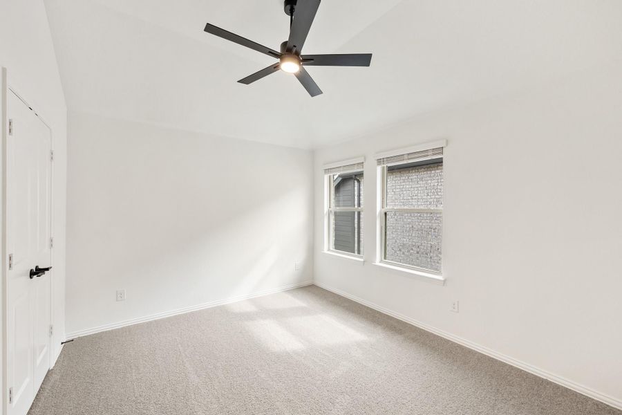 Empty bedroom with carpet flooring, ceiling fan, white walls, and two windows Empty bedroom with carpet flooring, ceiling fan, white walls, and two windows