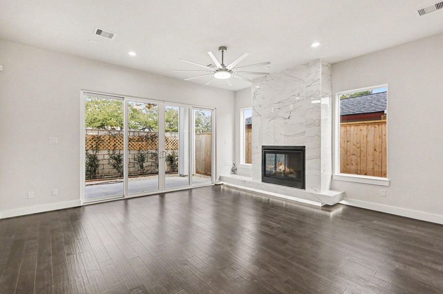 Designer fireplace with dramatic marble surround creates a stunning focal point.