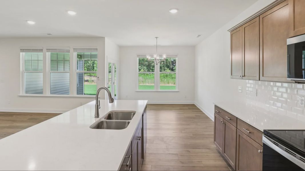 Pendleton home plan open concept kitchen with large island and abundant cabinetry overlooking family and breakfast