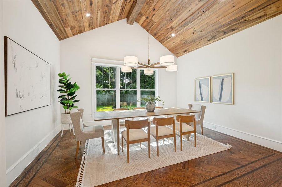 Vaulted wood-paneled ceiling with exposed beams, herringbone wood-finish flooring, and recessed lighting