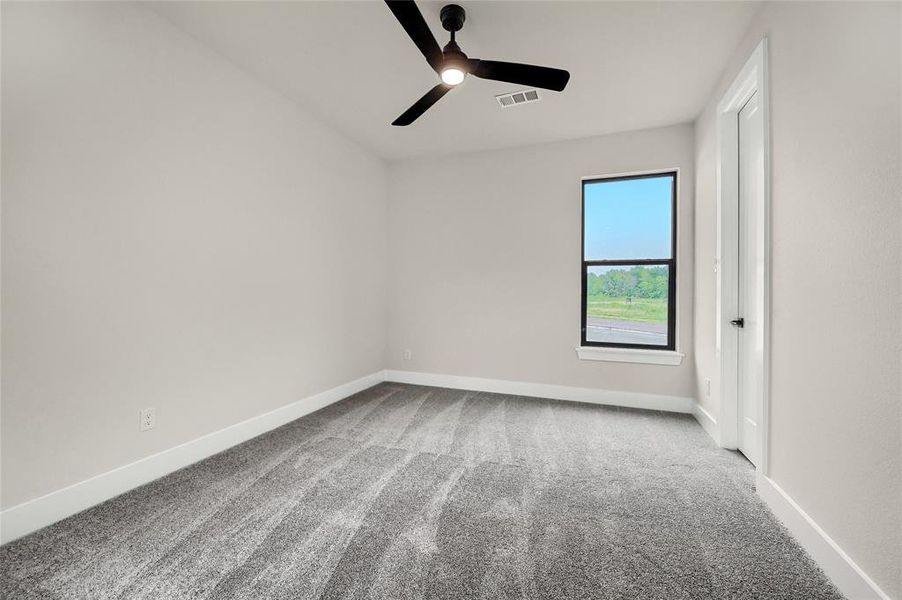 Spare room featuring ceiling fan and light carpet