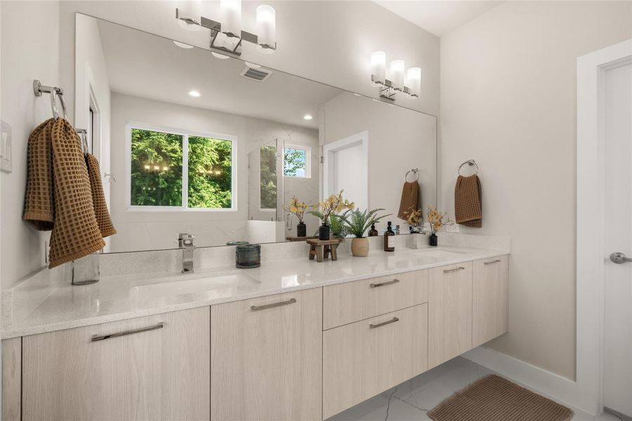Floating double vanity with ample storage, a large framed mirror & custom lighting that brings a touch of sophistication to the primary bath.