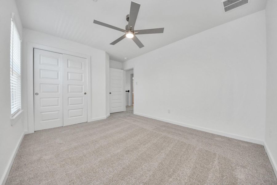 Generously sized secondary bedrooms featuring spacious closets, soft and inviting carpeting underfoot, large windows allowing plenty of natural light, and the added touch of privacy blinds for your personal retreat. Sample photo of completed home with similar floor plan. Actual colors and selections may vary.