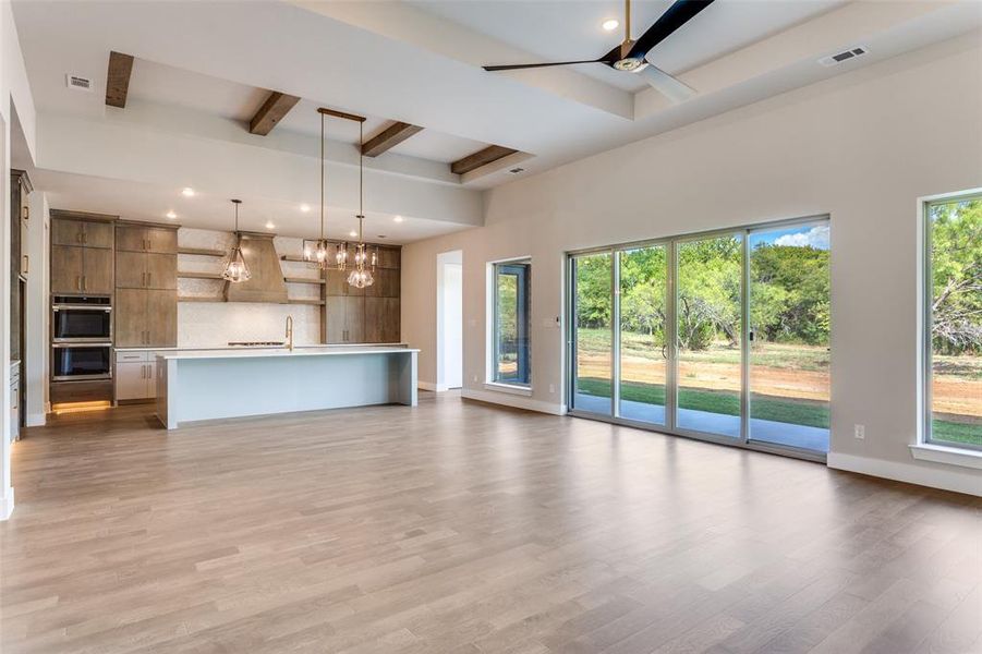 Unfurnished living room featuring beam ceiling, light wood-style flooring, recessed lighting, and ceiling fan Unfurnished living room featuring beam ceiling, light wood-style flooring, recessed lighting, and ceiling fan