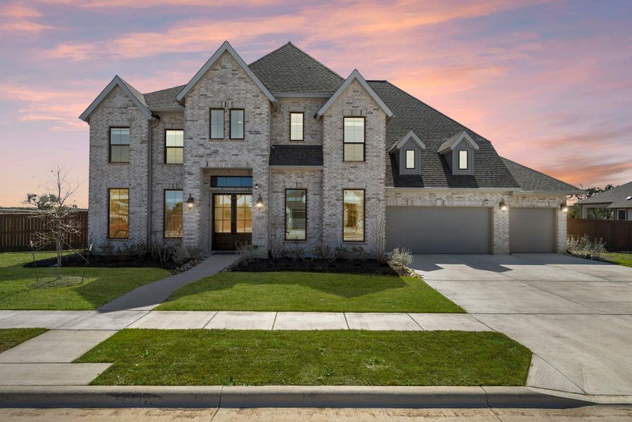 French country style house featuring driveway, an attached garage, fence, a yard, and brick siding