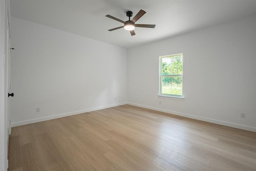 Spare room featuring light wood-type flooring and a ceiling fan Spare room featuring light wood-type flooring and a ceiling fan