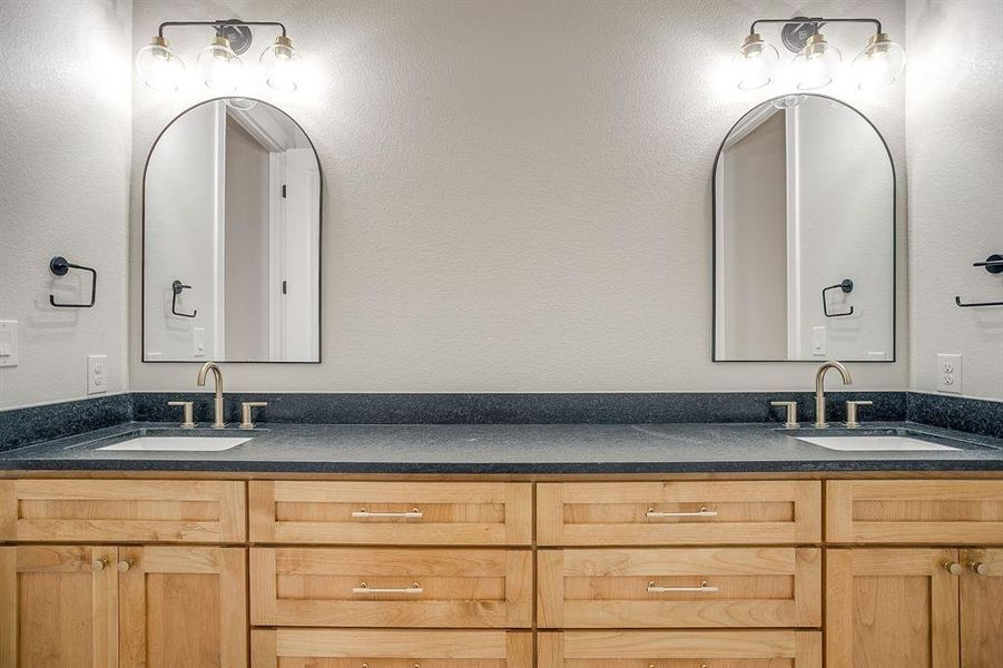 Full bathroom with double vanity and a textured wall Full bathroom with double vanity and a textured wall